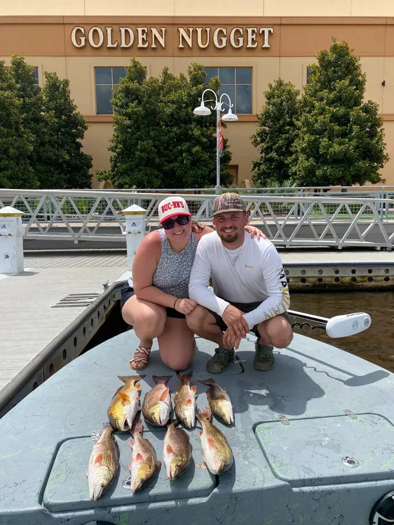 Two clients aboard the boat with their redfish catch at Golden Nugget