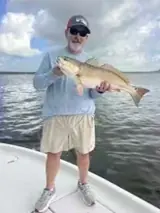 Photo attached to Cody’s review: angler holding a redfish aboard the boat